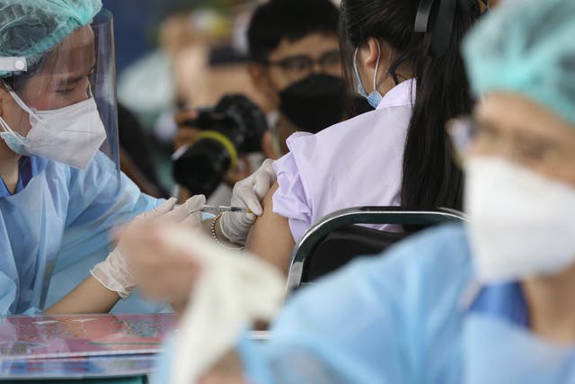 <p>A health official administers a dose of the Pfizer vaccine to a student during the initiation of a Covid-19 vaccination drive for students at Pibool Uppatham school, in Bangkok, Thailand on 4 October 2021</p>