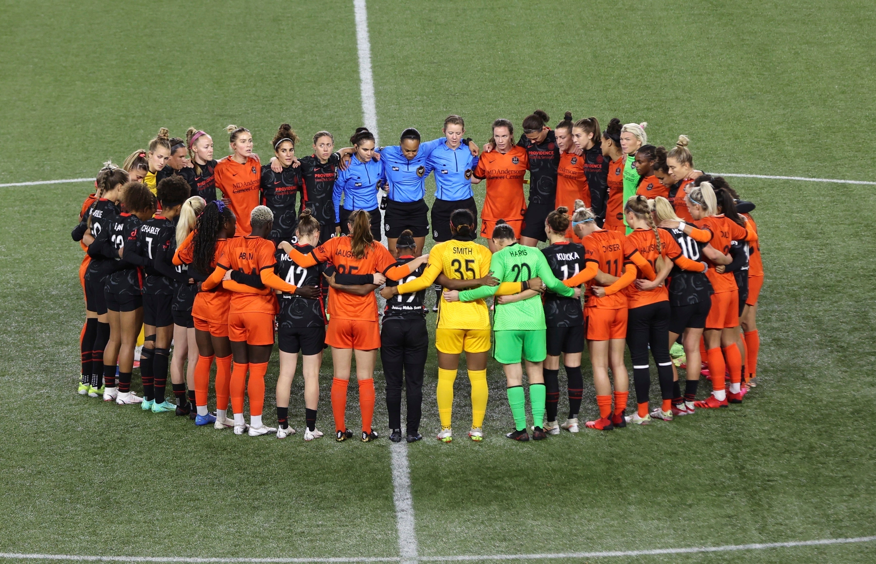 <p>Players gather in the centre circle during the match between Portland Thorns and Houston Dash (Steve Dipaola/AP)</p>