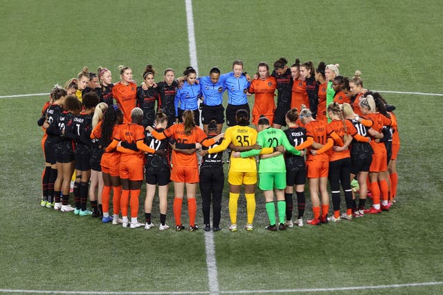 <p>Players gather in the centre circle during the match between Portland Thorns and Houston Dash (Steve Dipaola/AP)</p>