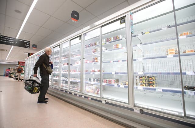 Brexit significa estantes vacíos. Un comprador mira productos y estantes vacíos del pasillo de la carne en una cooperativa en Harpenden