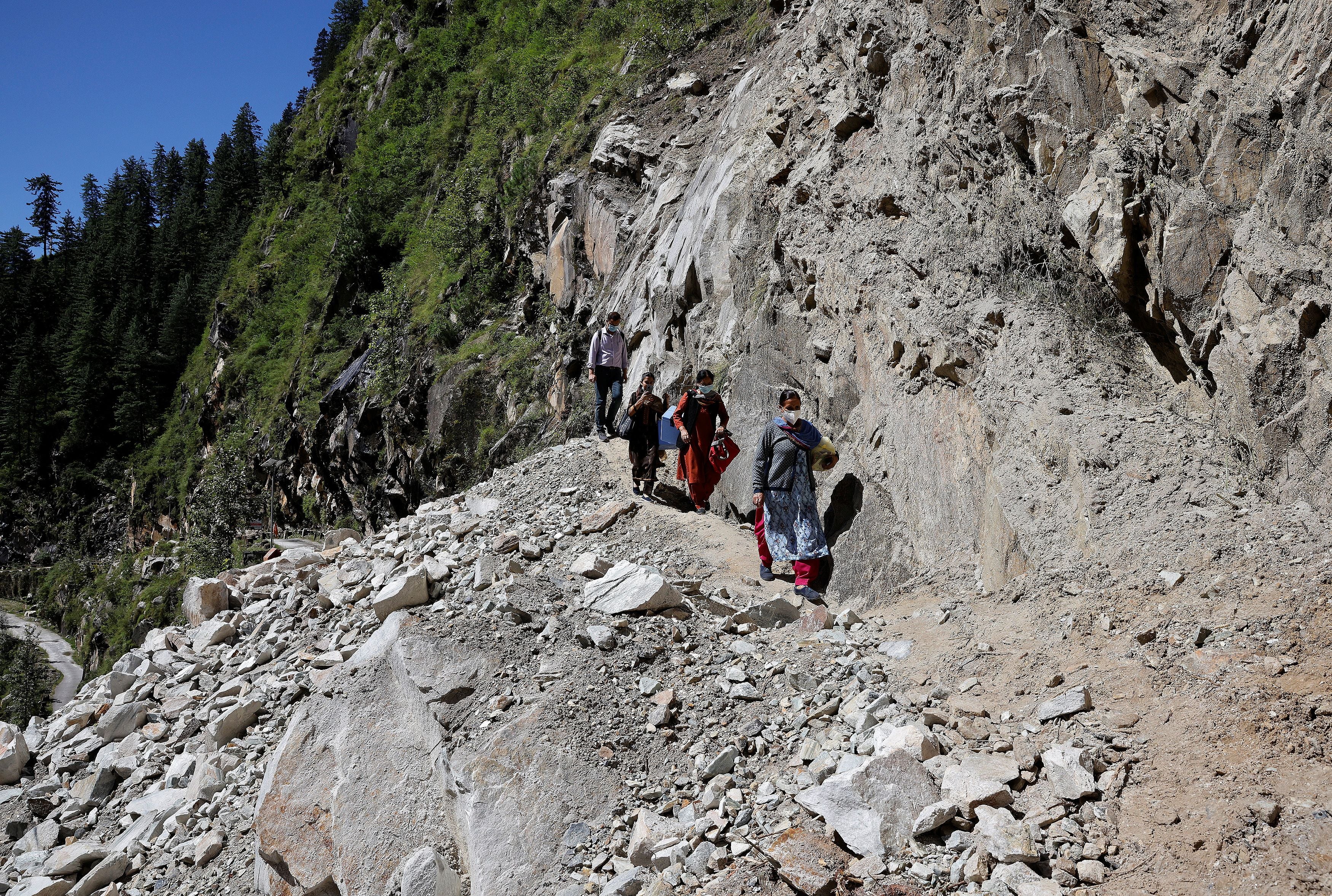 The team traverse a road that was blocked by a landslide