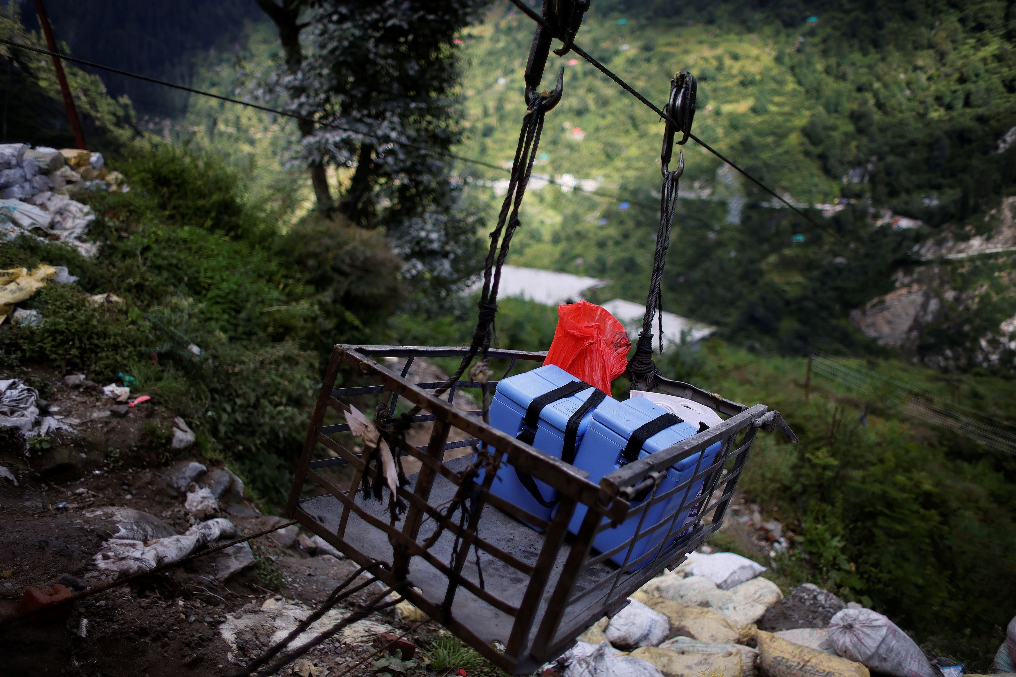 Boxes containing vaccines are trollied across a river gorge to Malana