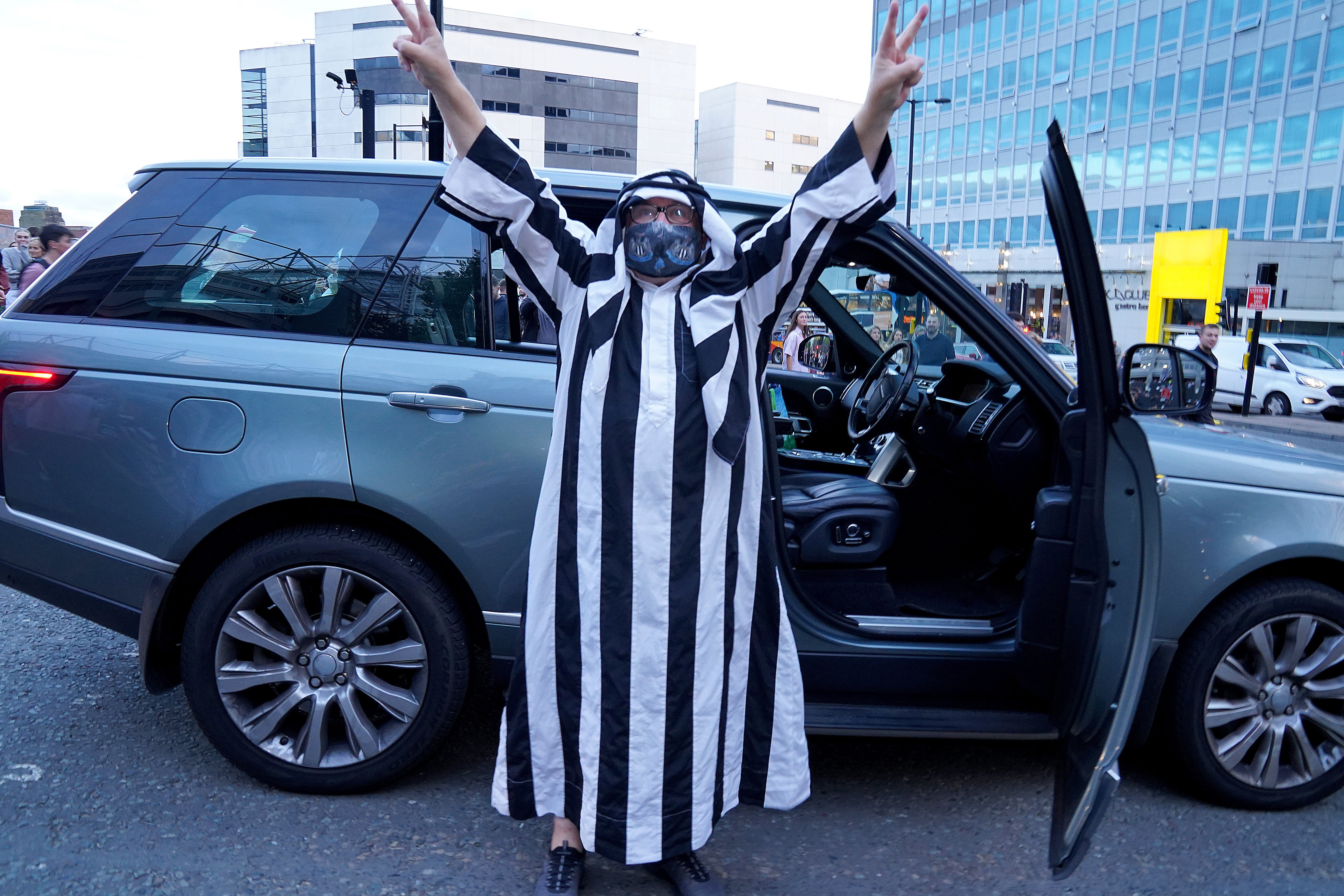 A Newcastle fan shows his joy at the takeover news (Owen Humphreys/PA).