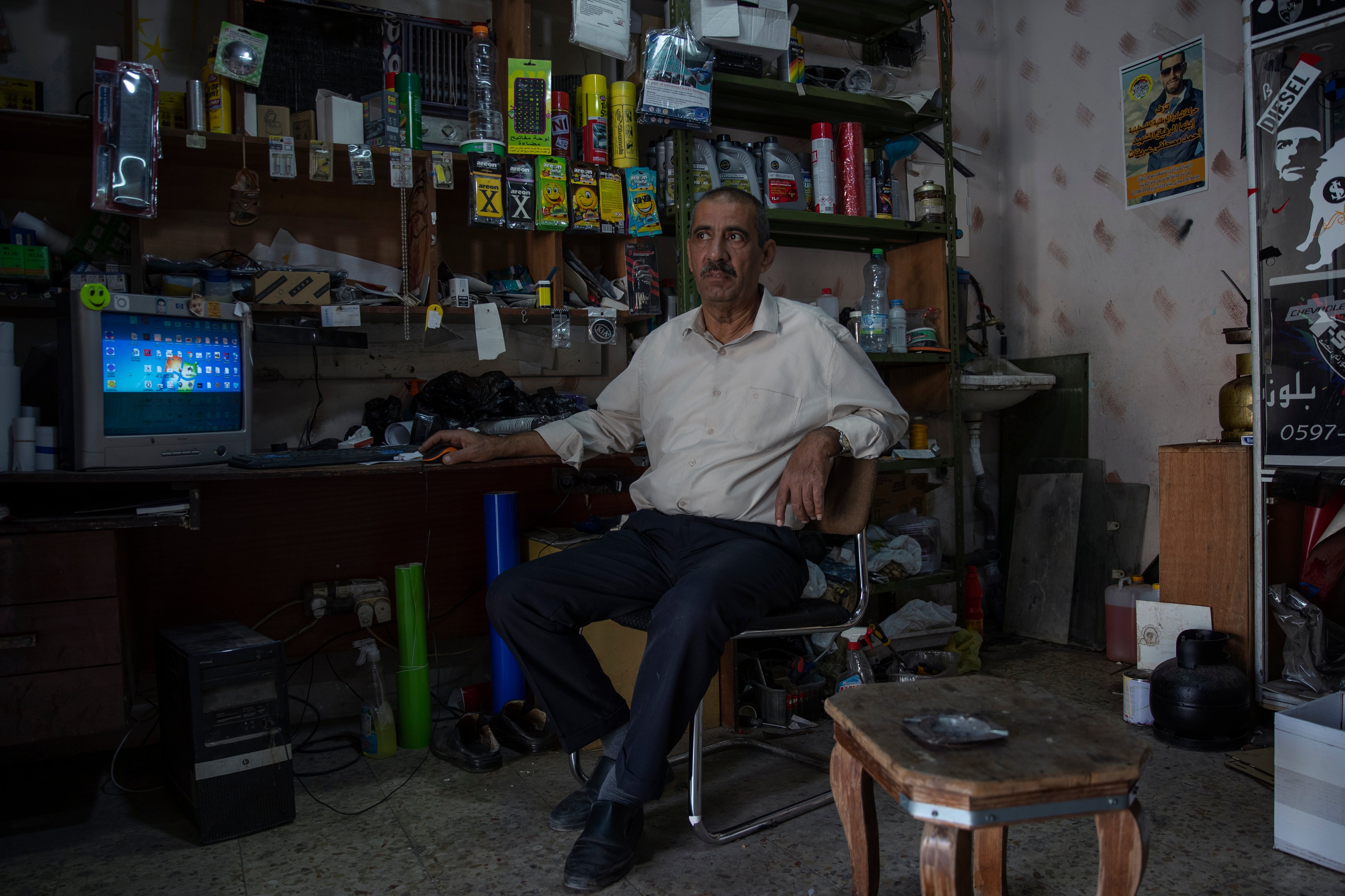 Palestinian Mustafa Erekat, whose son Ahmed was shot dead by Israeli forces at a West Bank checkpoint last year and held his body after, sits at his shop in the village of Abu Dis, South of Ramallah