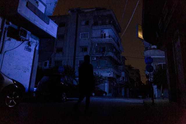 <p>A man walks through Beirut during a blackout</p>