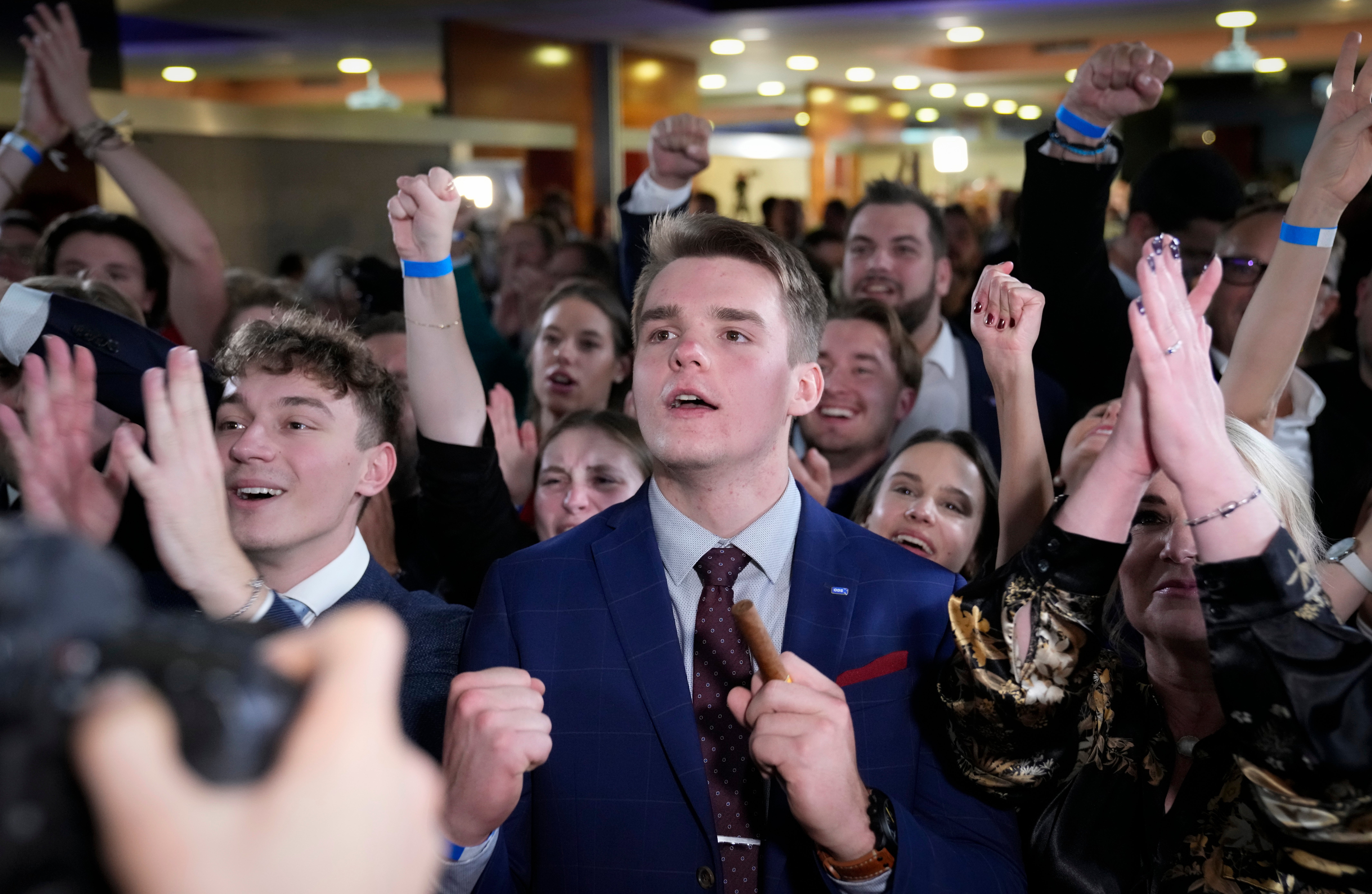 Supporters of leader of centre-right Spolu (Together) coalition Petr Fiala react to election results in Prague