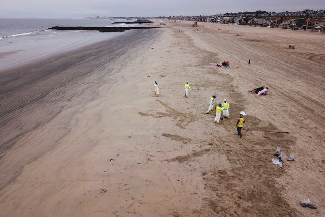 <p>In this aerial image taken on October 7, 2021 clean up crews collect bags of debris from the beach after an oil spill in the Pacific Ocean in Newport Beach, California</p>