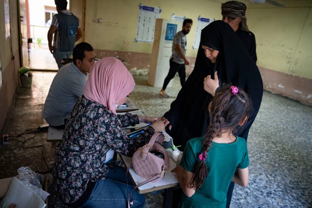 <p>An Iraqi couple vote for independents in Sadr City for the national elections</p>