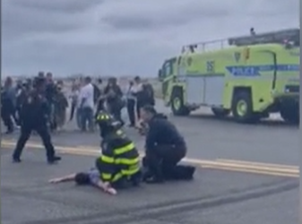 The American Eagle passenger is pinned down by airport staff