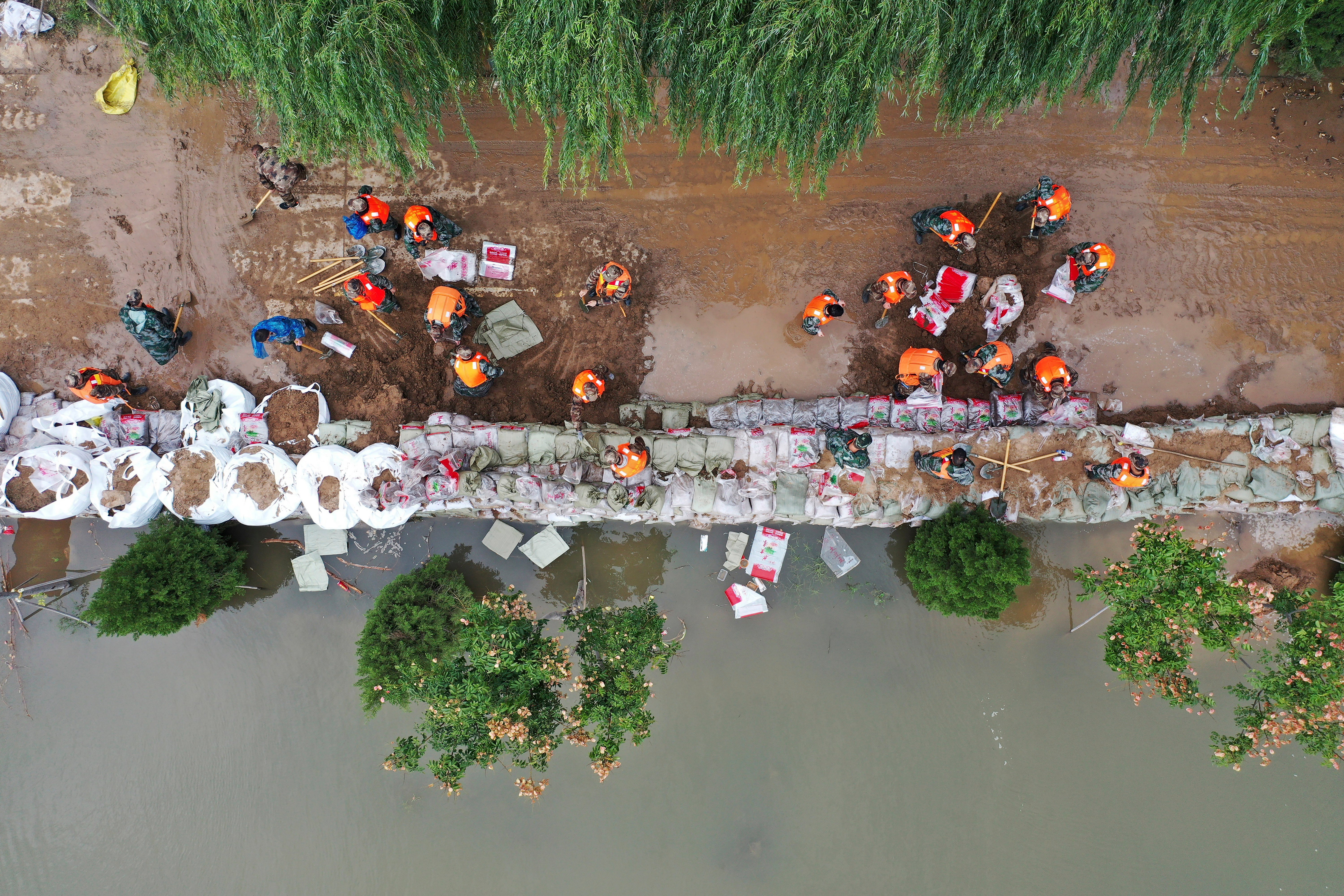 Rescuers fortifying a temporary dyke against the flooding at the Lianbo Village in Hejin City, in northern China’s Shanxi Province, on Sunday