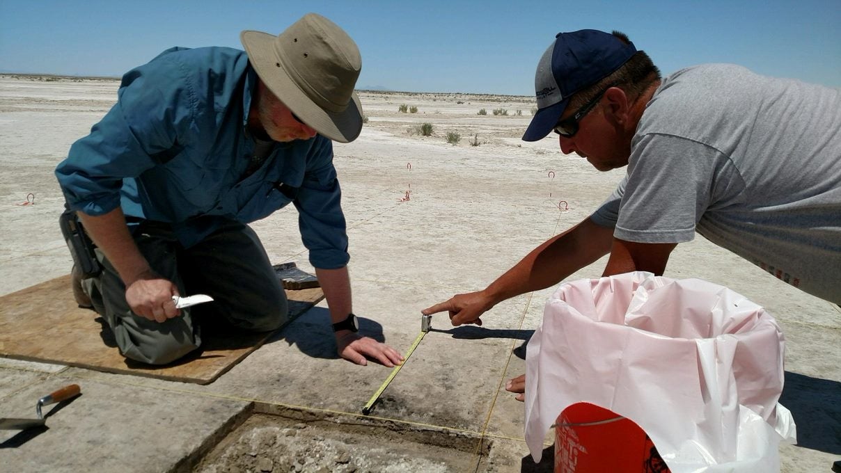 Archaeologist Daron Duke (L) and colleague Michael Shane work in this undated handout photo released to Reuters on October 11, 2021 at an ancient hearth dating to 12,300 years ago at the Wishbone site in Great Salt Lake Desert in northern Utah