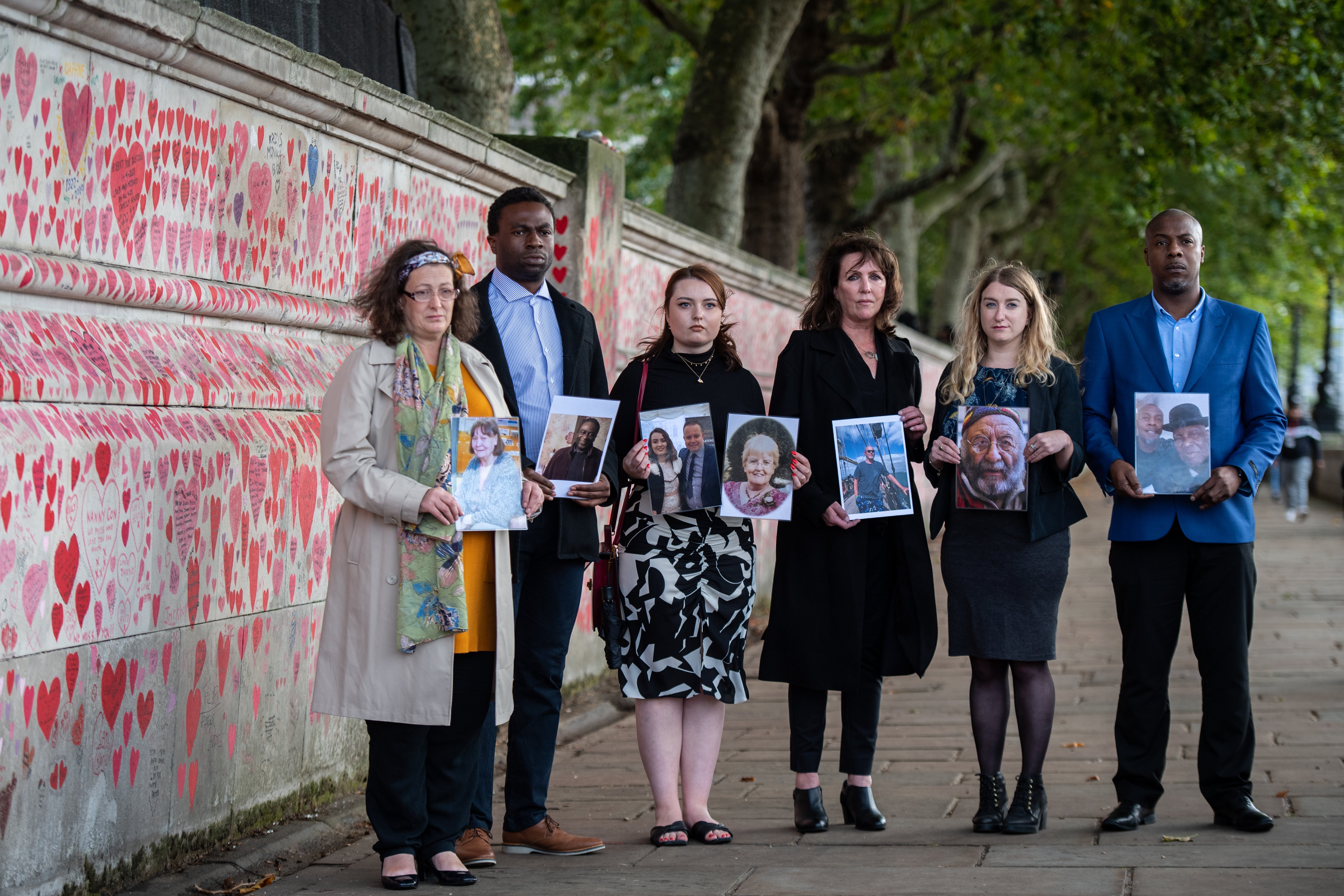 Representatives from Covid-19 Bereaved Families for Justice, (L-R) Deborah Doyle, Lobby Akinnola, Hannah Brady, Fran Hall, Jo Goodman and Charlie Williams next to the Covid Memorial Wall they helped create