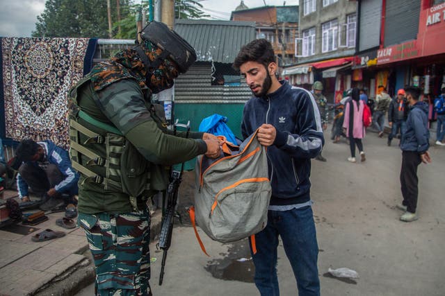 <p>An Indian soldier checks the bag of a Kashmiri man at a busy market in Srinagar </p>