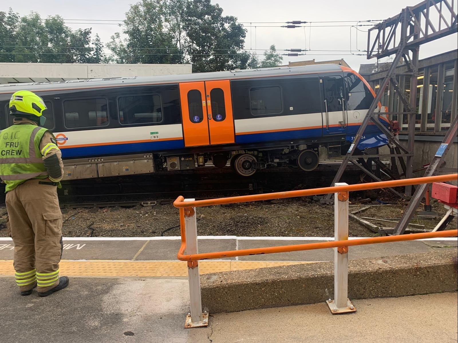 Two people have been treated for minor injuries after an eight-carriage London Overground train crashed into buffers at Enfield Town station, causing it to derail.