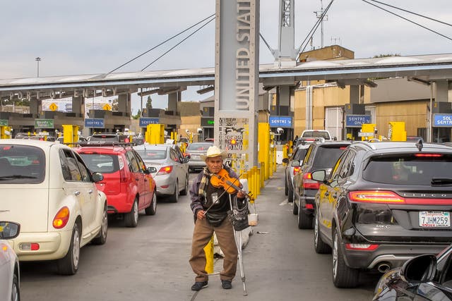 <p>An elderly person plays his violin among the dozens of cars queued on the Mexican side waiting to cross the border between Mexico and the United States, at the border station between Tijuana and San Ysidro.</p>