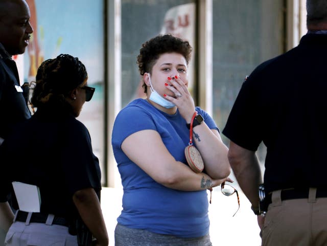 <p>Family members of victims wait with Memphis Police Department officers outside of a post office after a shooting</p>