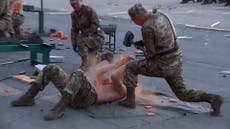 Bare-chested North Korean soldiers fight each other and punch concrete in display for smiling Kim Jong-un