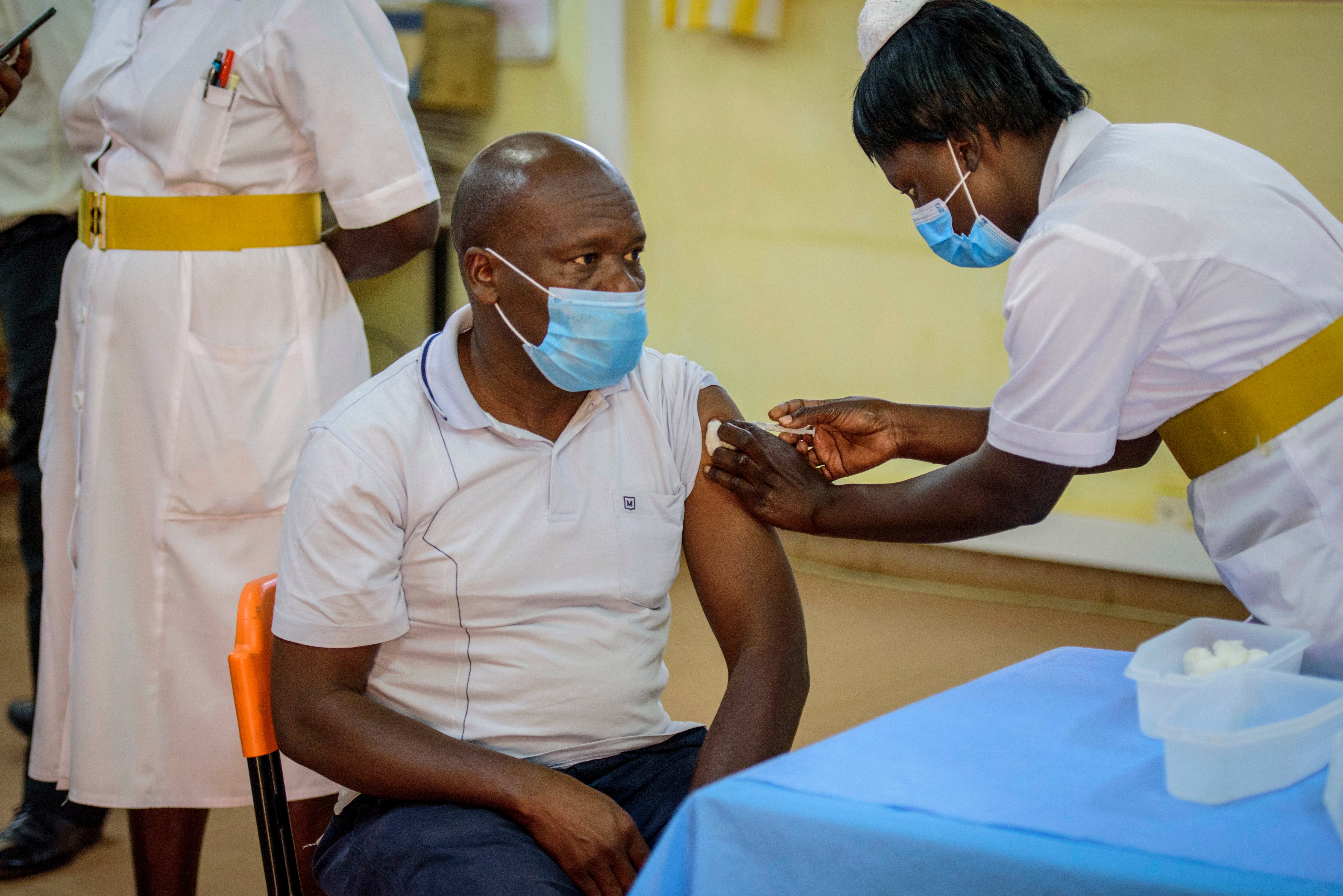 A nurse vaccinates a man against the coronavirus at St. Mary’s Hospital Lacor in Gulu, Uganda