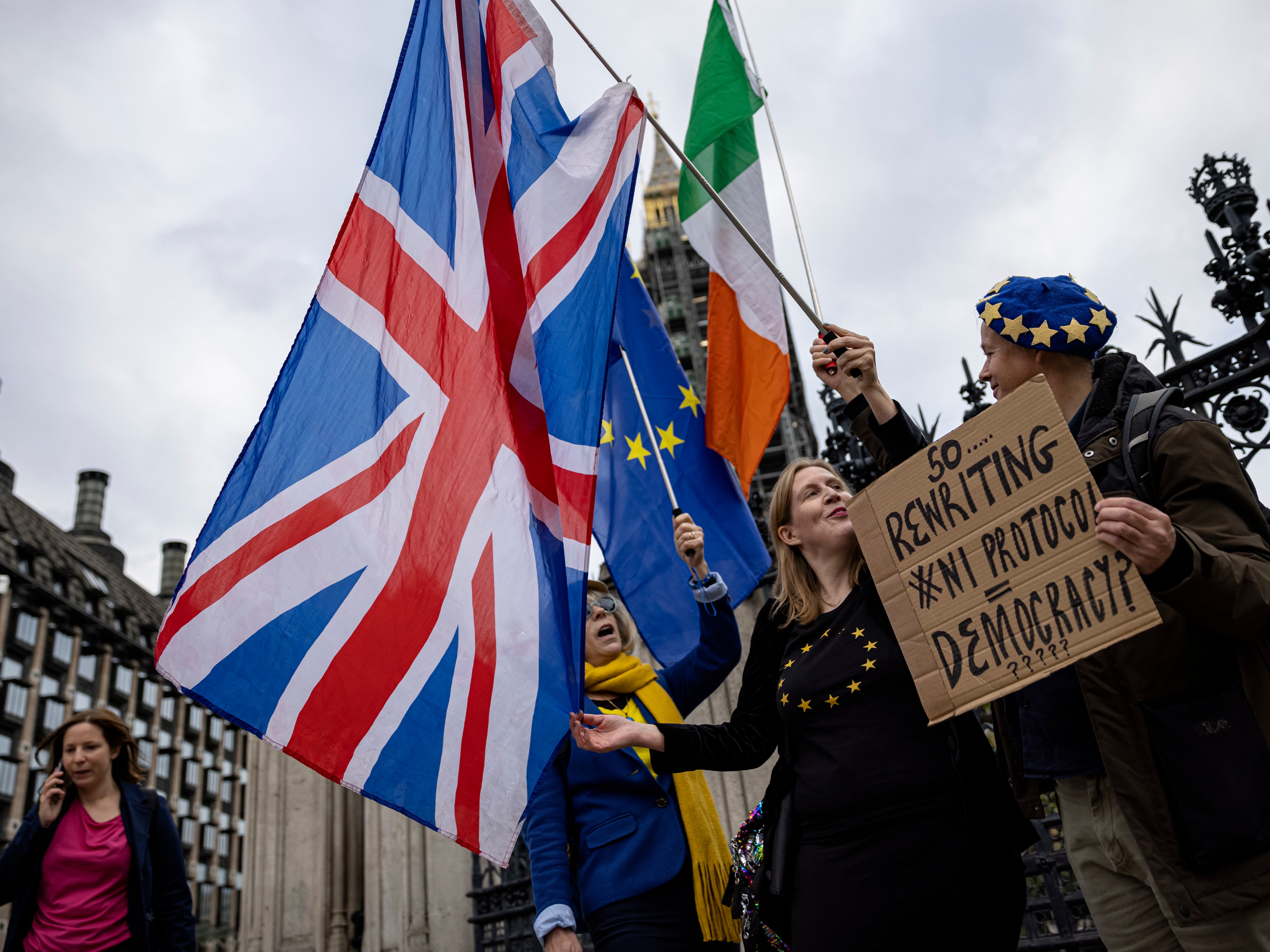 Anti-Brexit protesters wave the flags of the UK, Ireland and EU outside parliament