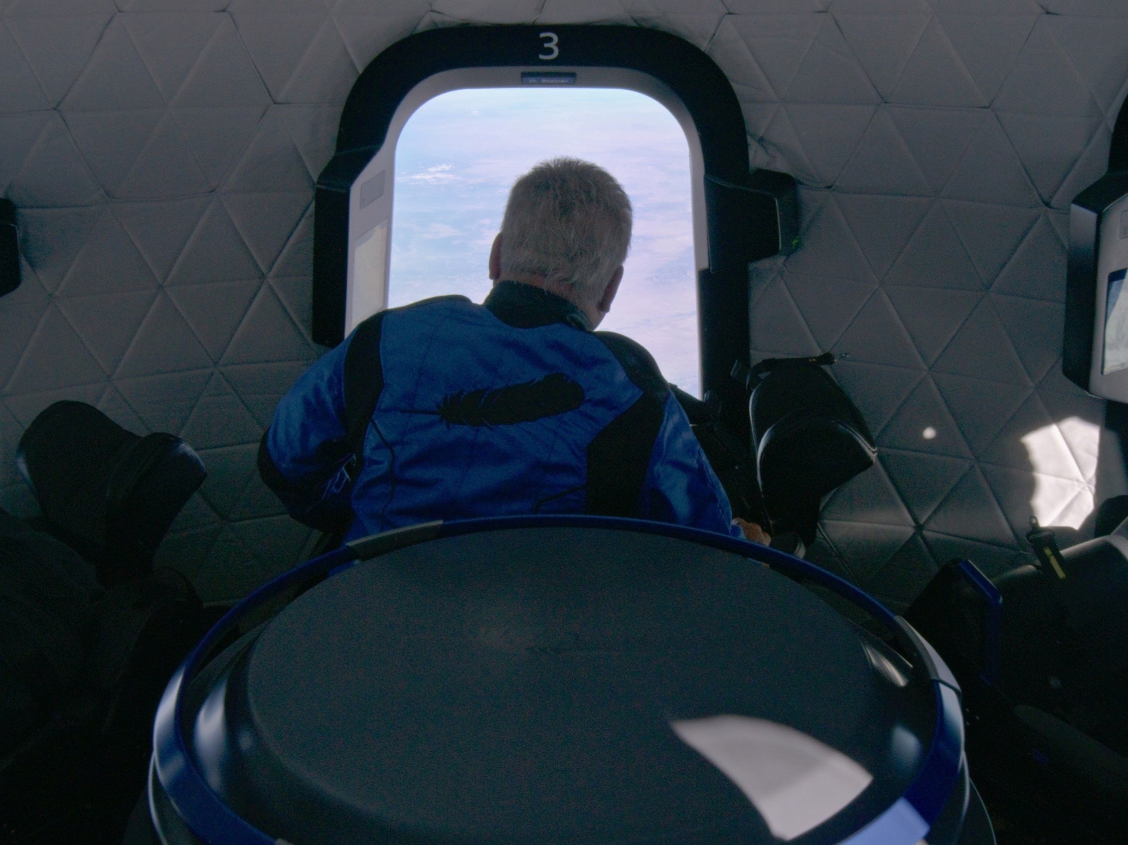 Shatner looks out a window aboard the Blue Origin space vehicle