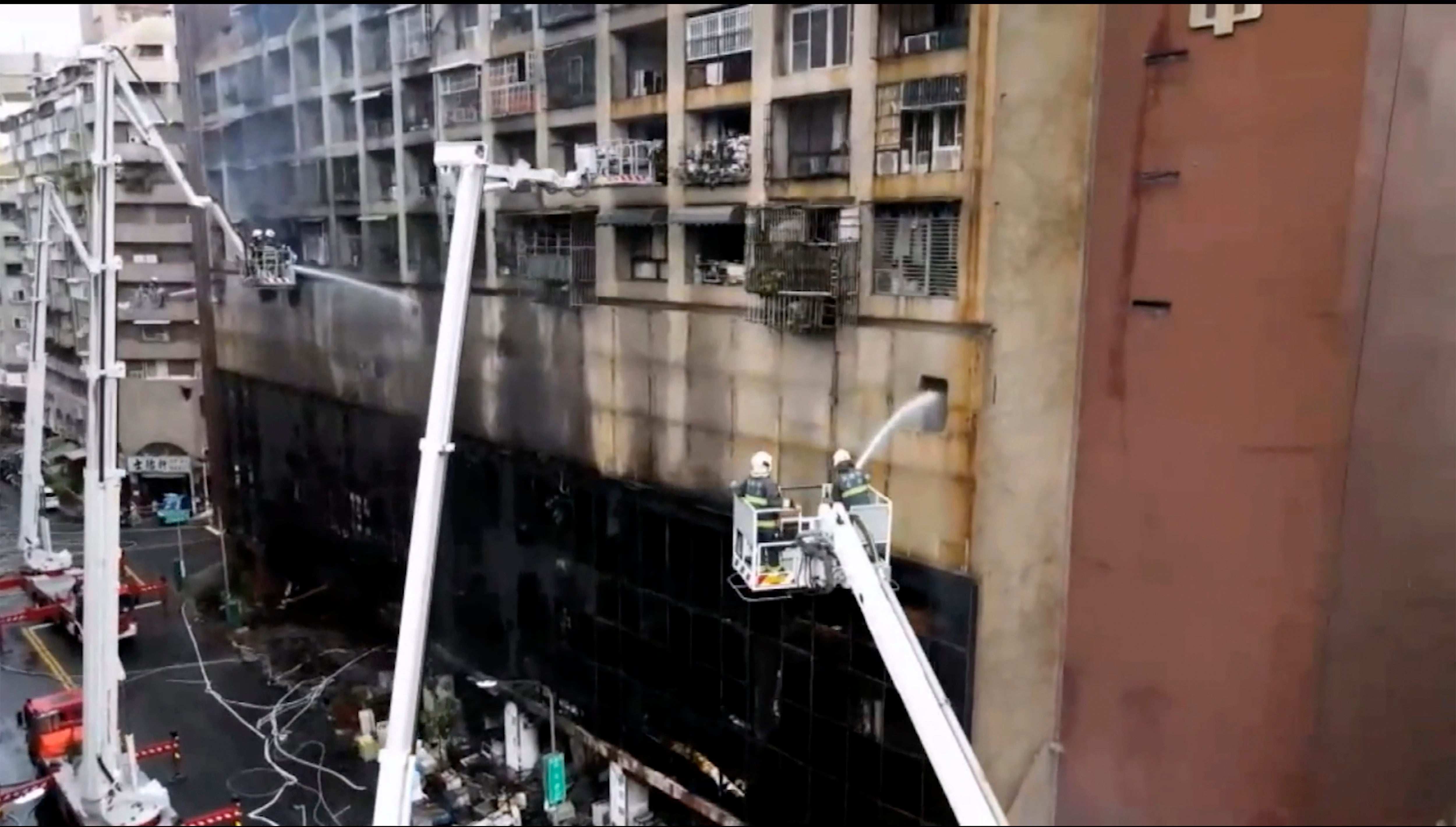 Firefighters jet water into the building