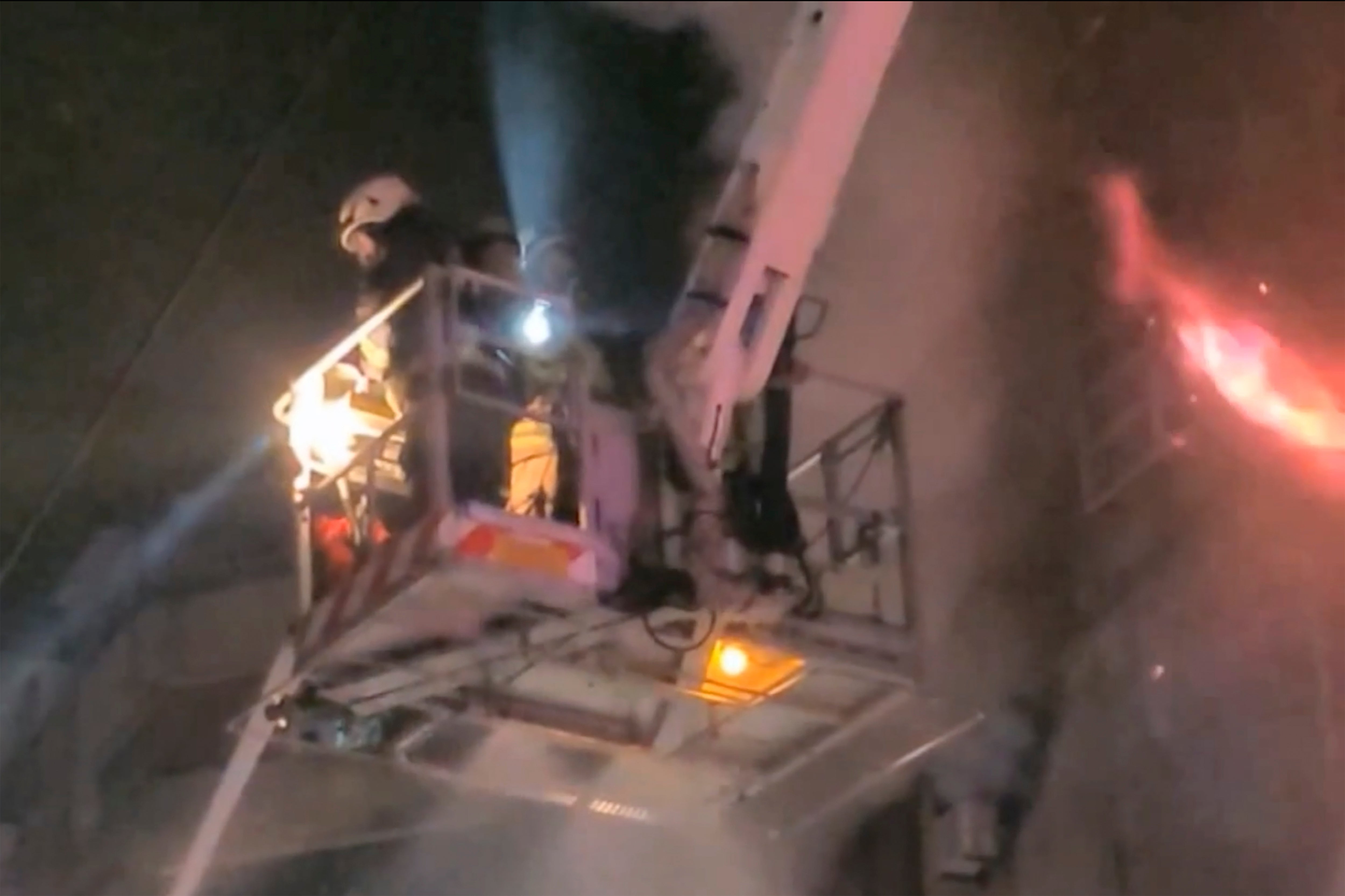 Firefighters on a crane tackle the blaze