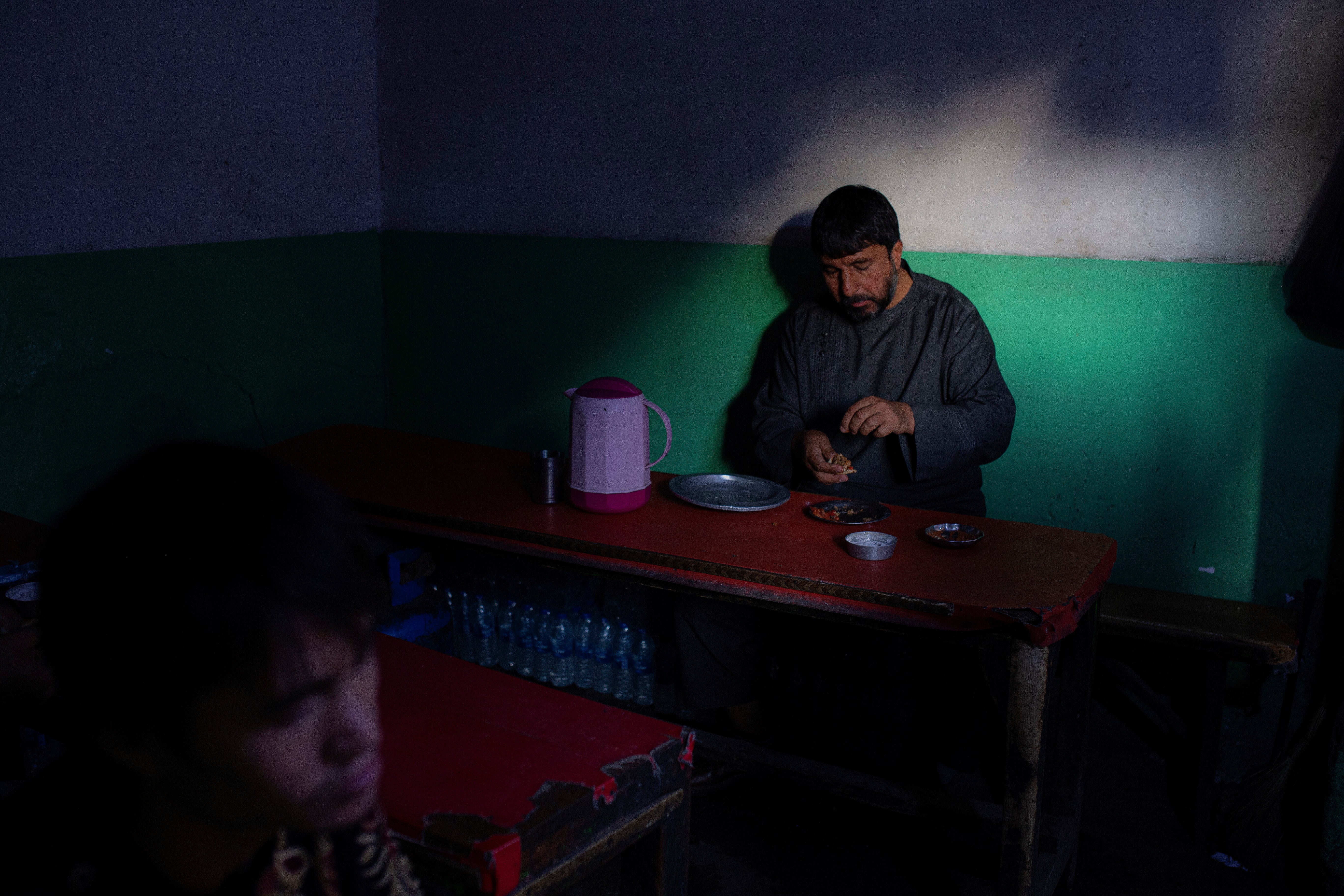 An Afghan man eats lunch at a market restaurant in Kabul