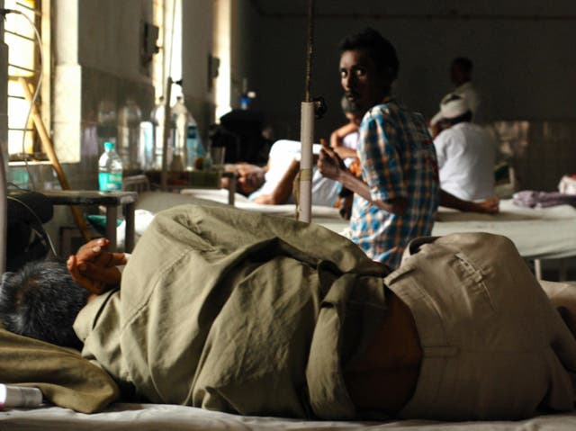 <p>An tuberculosis patient looks on while another one coughs on a bed in a ward of the TB Civil Hospital in Ahmedabad, India</p>