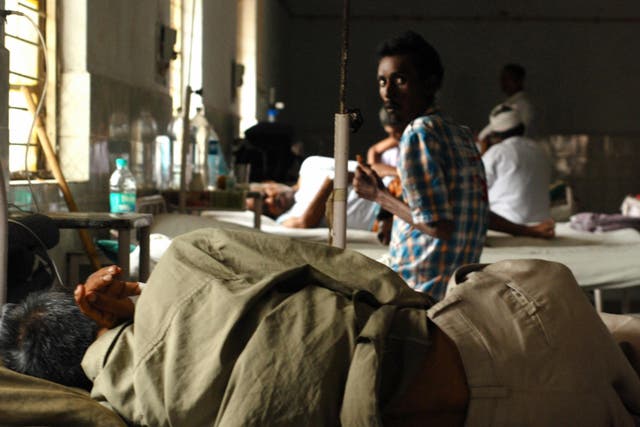 <p>An tuberculosis patient looks on while another one coughs on a bed in a ward of the TB Civil Hospital in Ahmedabad, India</p>