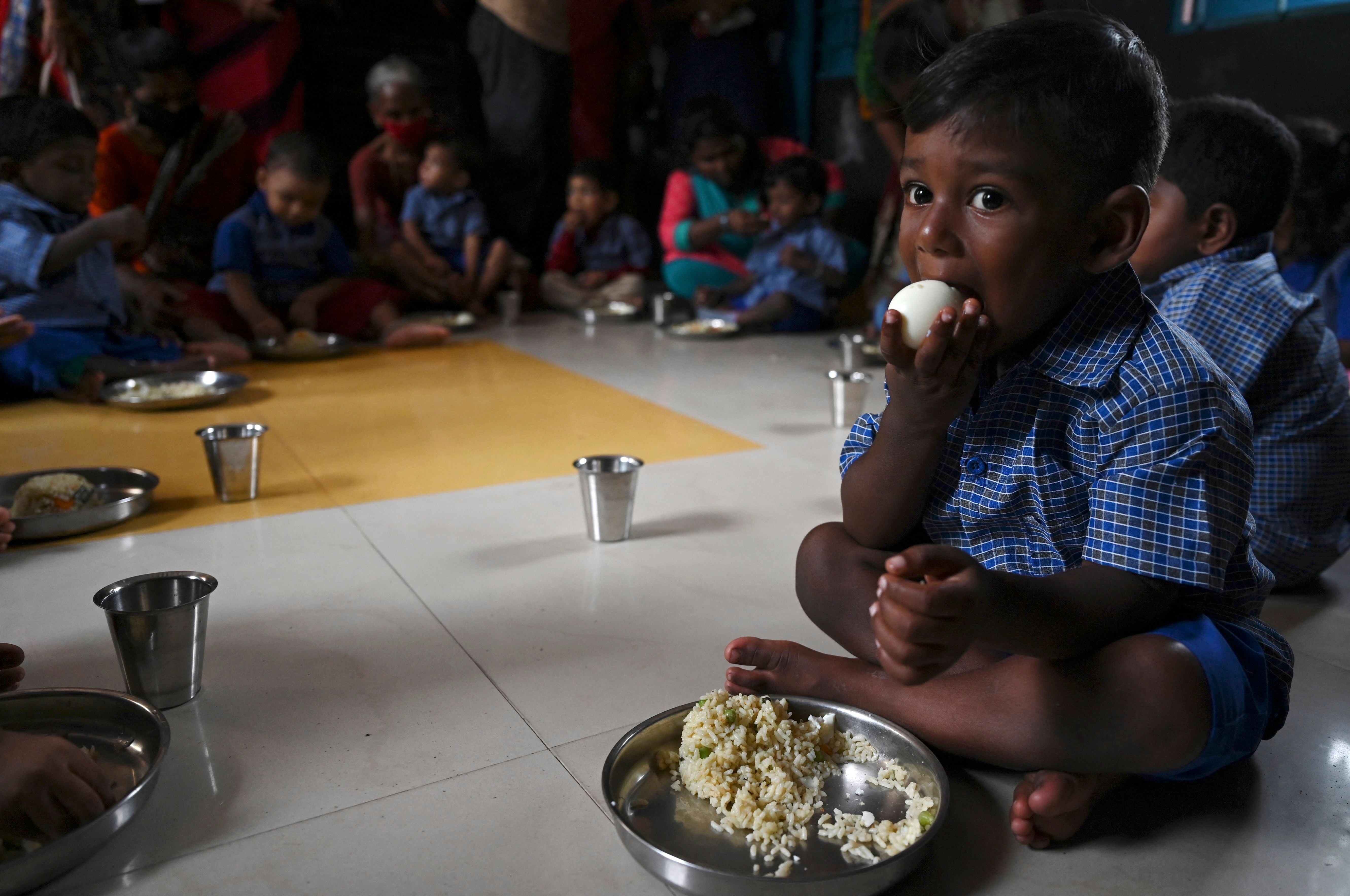 Children eat a meal at a pre-school in Chennai on 1 September 2021, after the state government relaxed the Covid-19 coronavirus lockdown norms for educational institutions, allowing students to attend physical classes