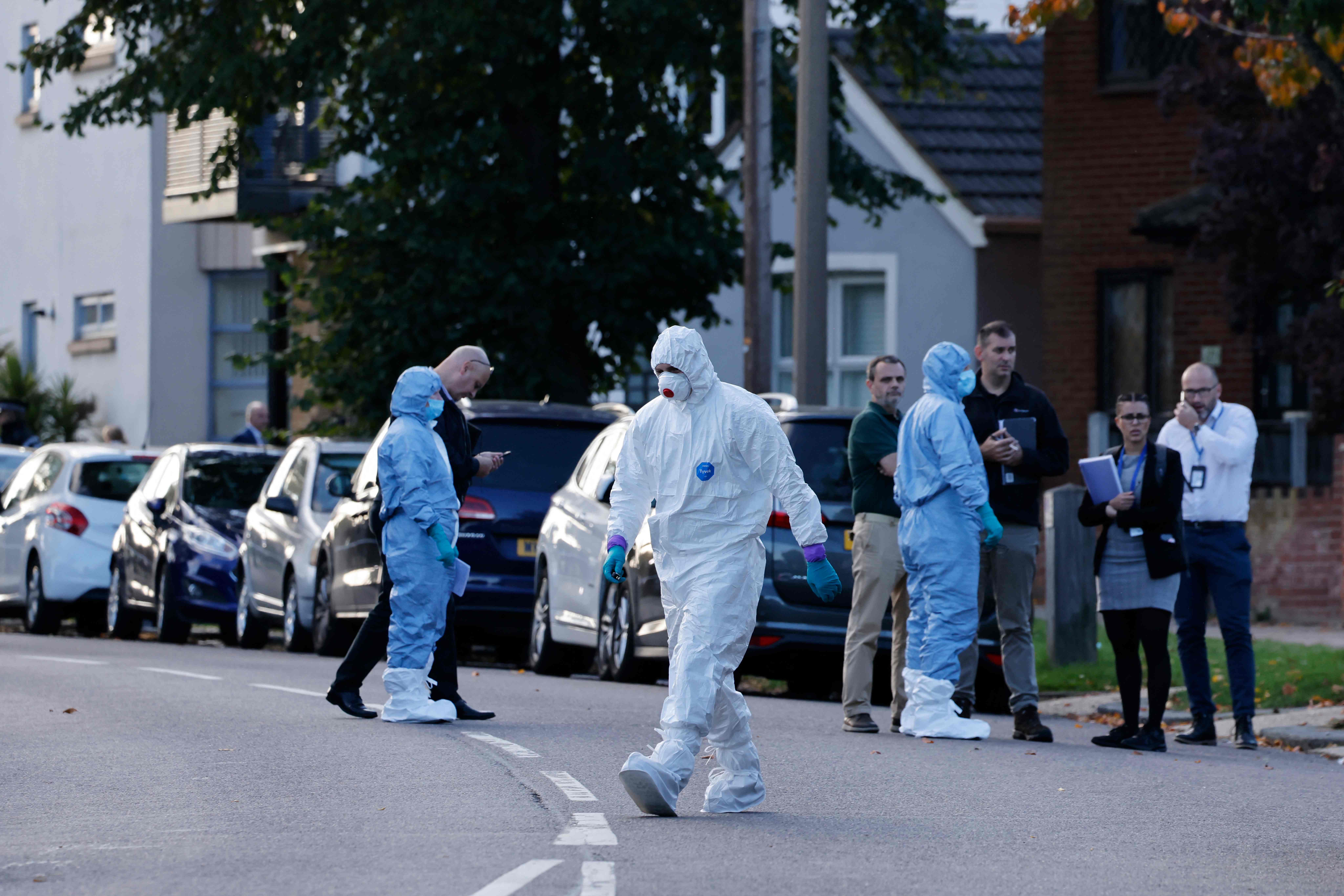 Police forensics officers work at the scene