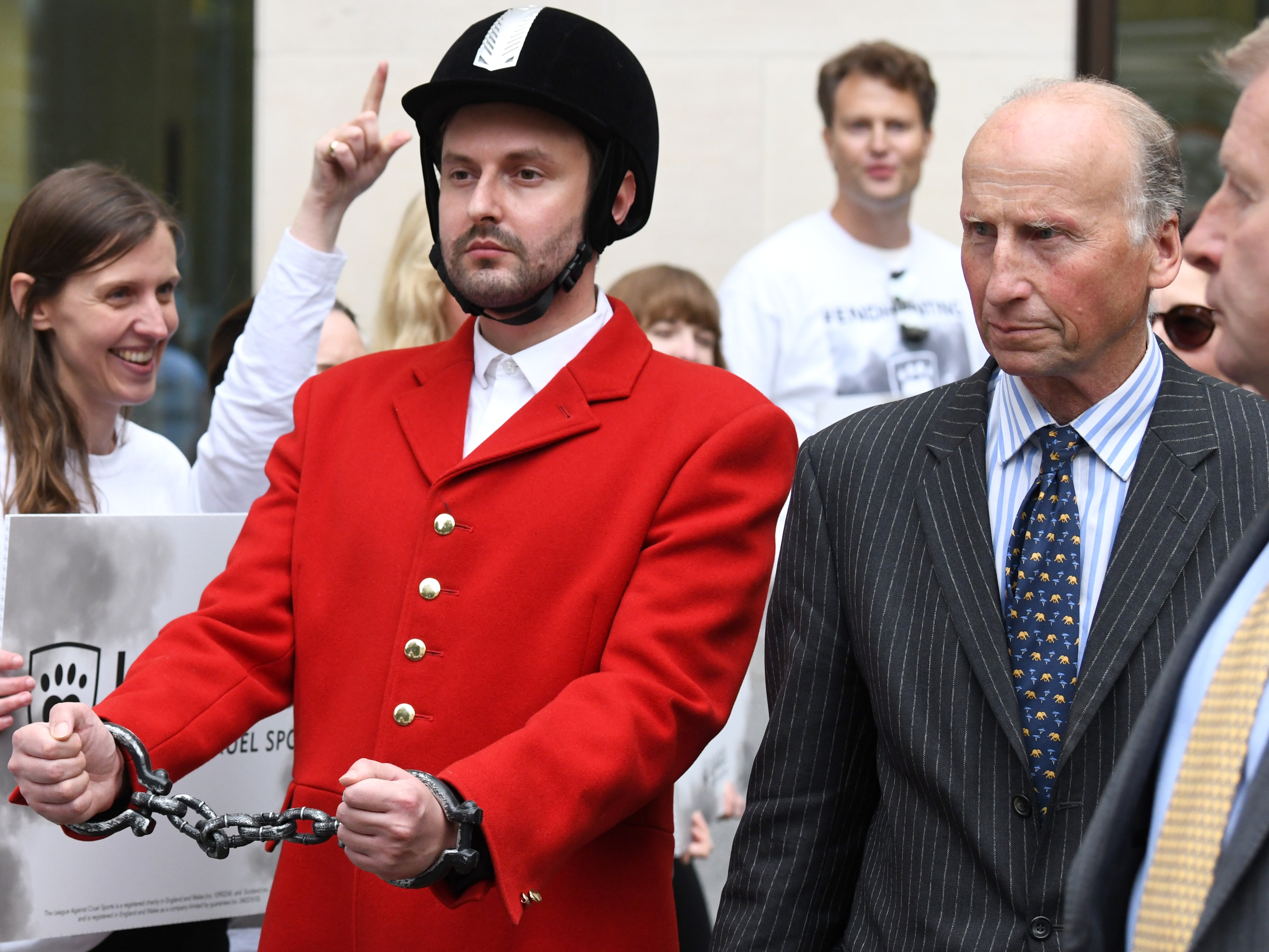 <p>Hankinson, right, leaves court as a hunt opponent makes a symbolic visual gesture </p>