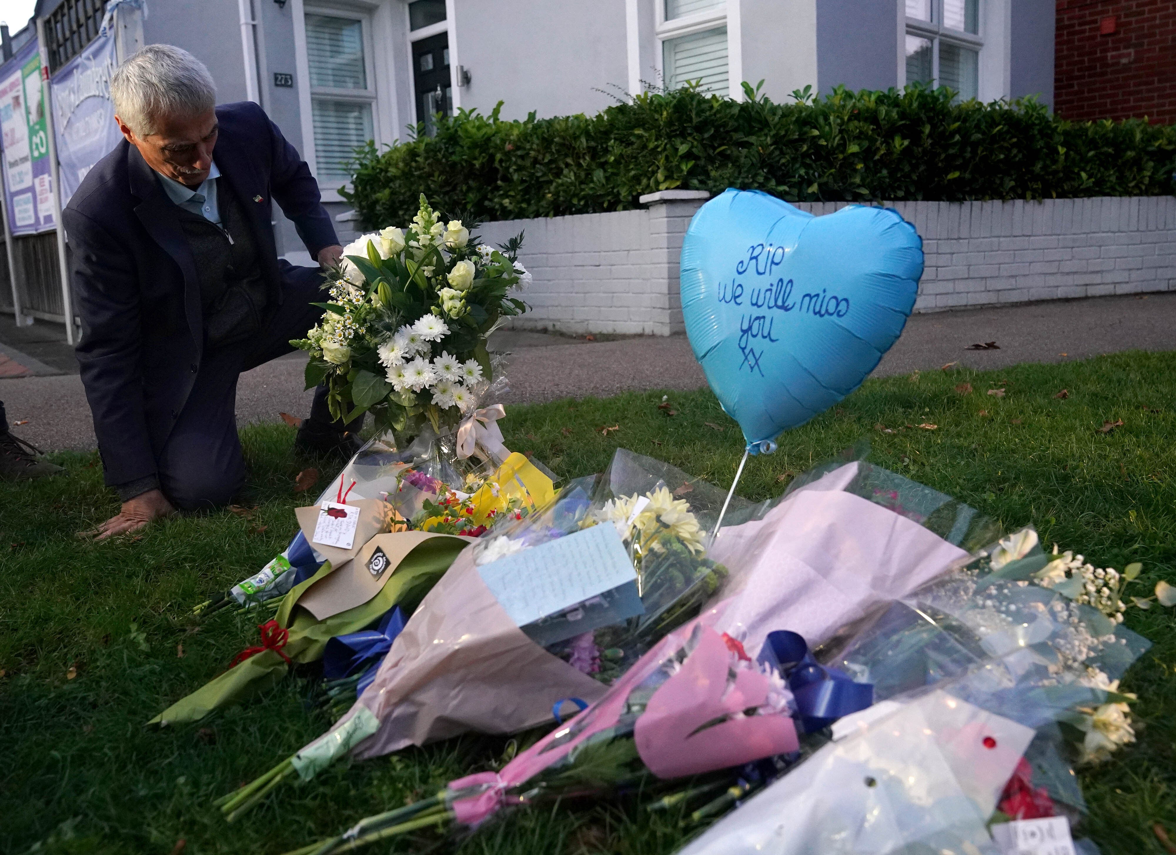 A man lays flowers in memory of Sir David Amess in Leigh-on-Sea