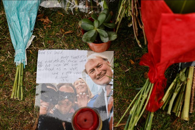 <p>A photograph of David Amess among the floral tributes left at Belfairs Methodist Church</p>