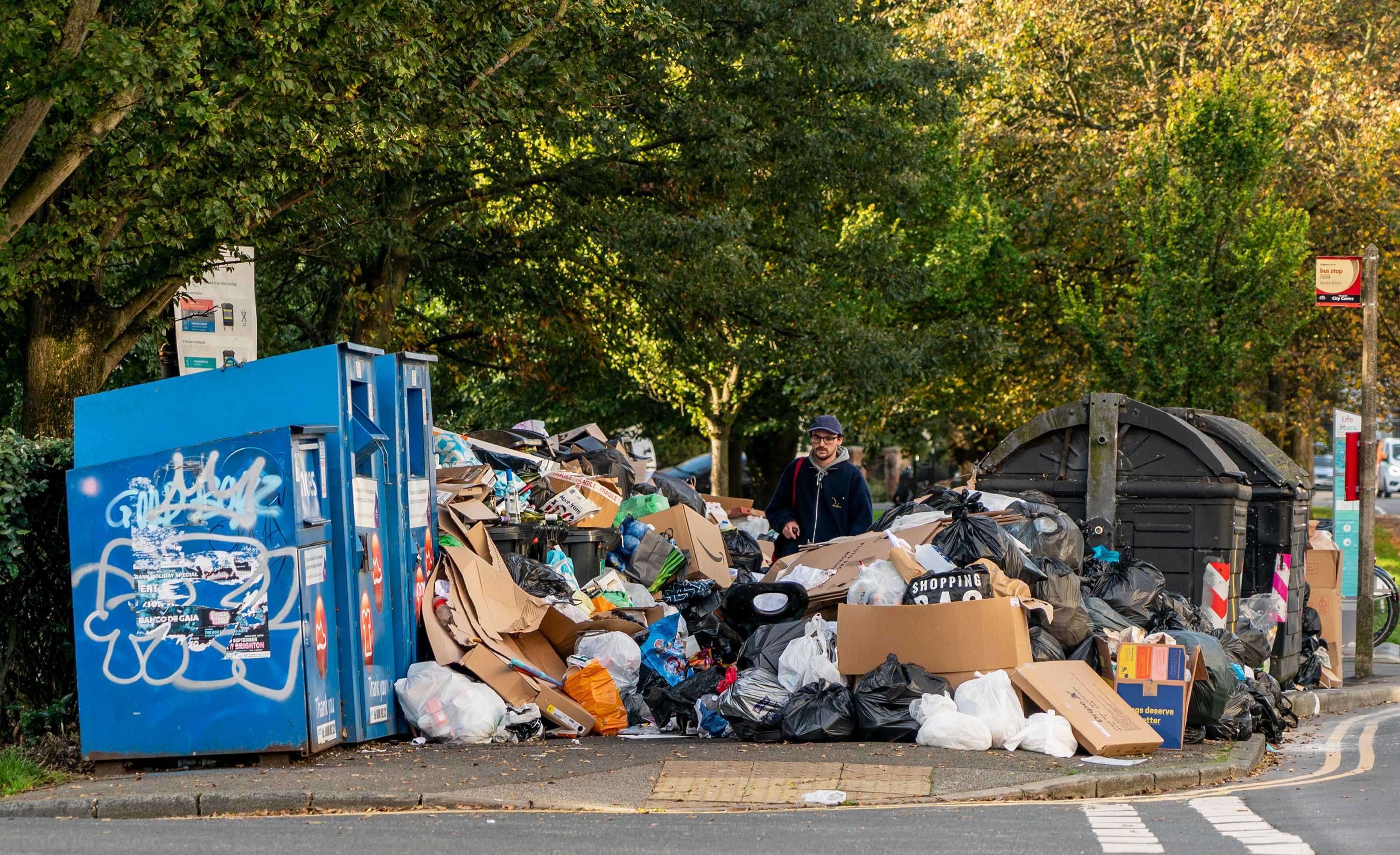 A man picks his way through the growing mountain of rubbish in Montpellier Terrace as the Brighton bin strike continues.