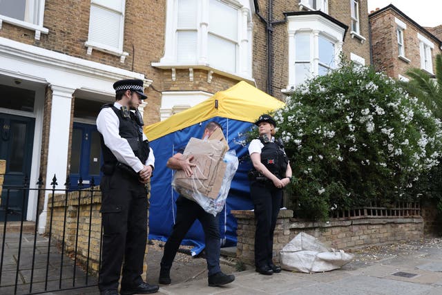 <p>Police stand guard outside a house linked to the suspect in Kentish Town, northwest London</p>
