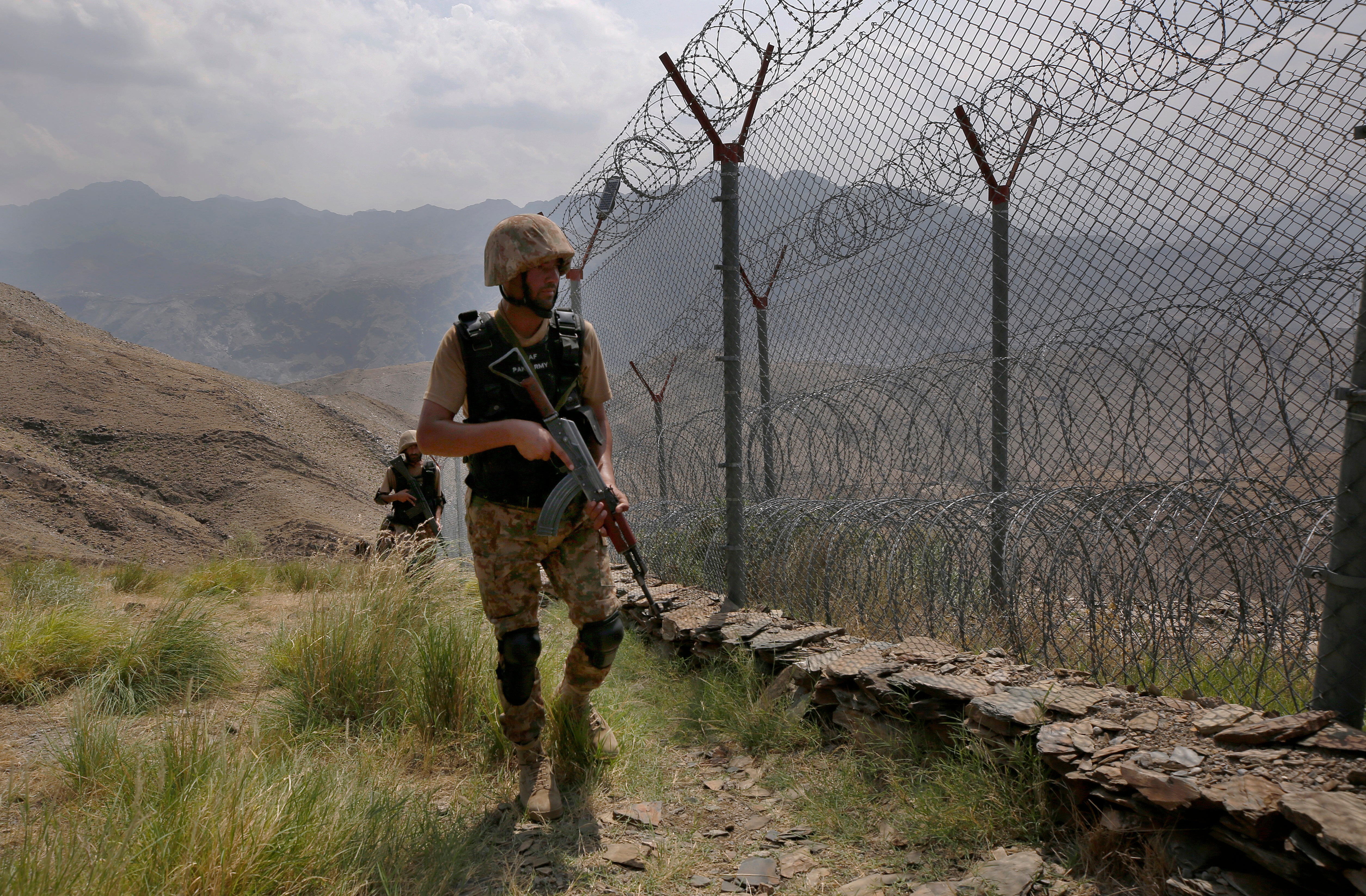 A Pakistani soldier patrols a fence on the border with Afghanistan