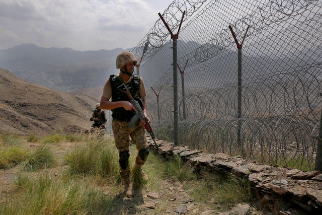 <p>A Pakistani soldier patrols a fence on the border with Afghanistan</p>