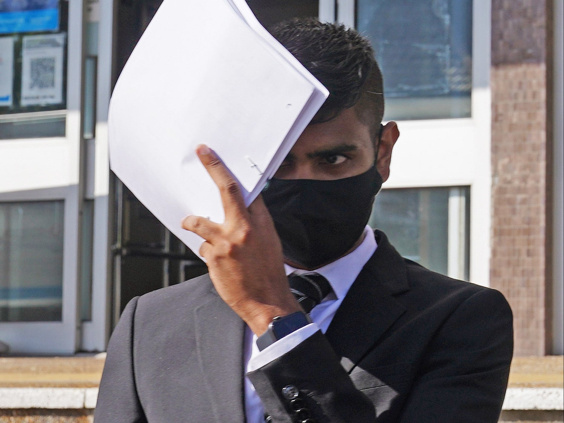 Javed Saumtally covers up as he leaves Hove Crown Court in August