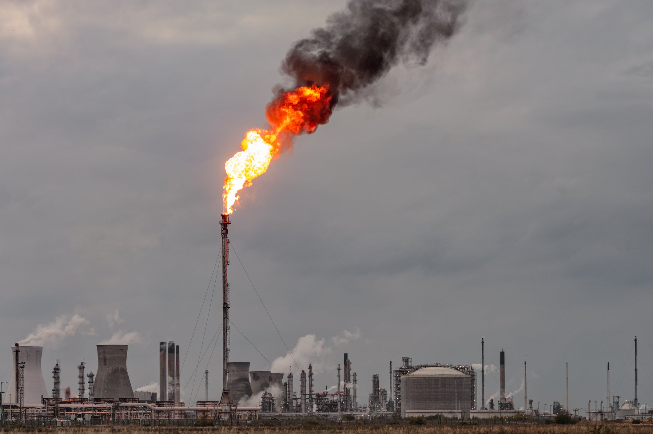 A large flame and dark smoke rising from a flare stack at Grangemouth oil refinery and petrochemical plant in Scotland