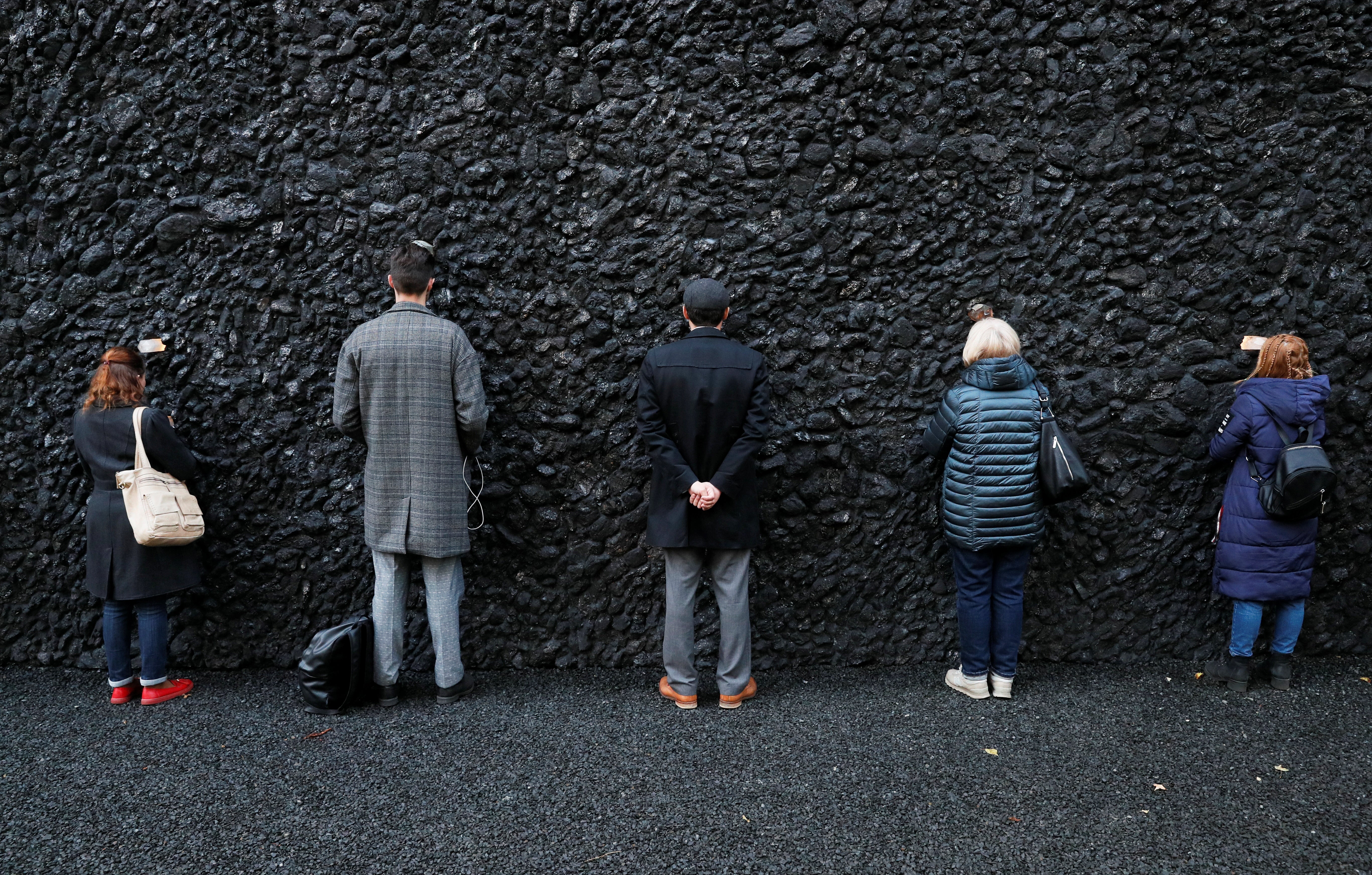 People take part in a performance by artist Marina Abramovic next to her artwork ‘Crystal Wall of Crying’ at Babyn Yar