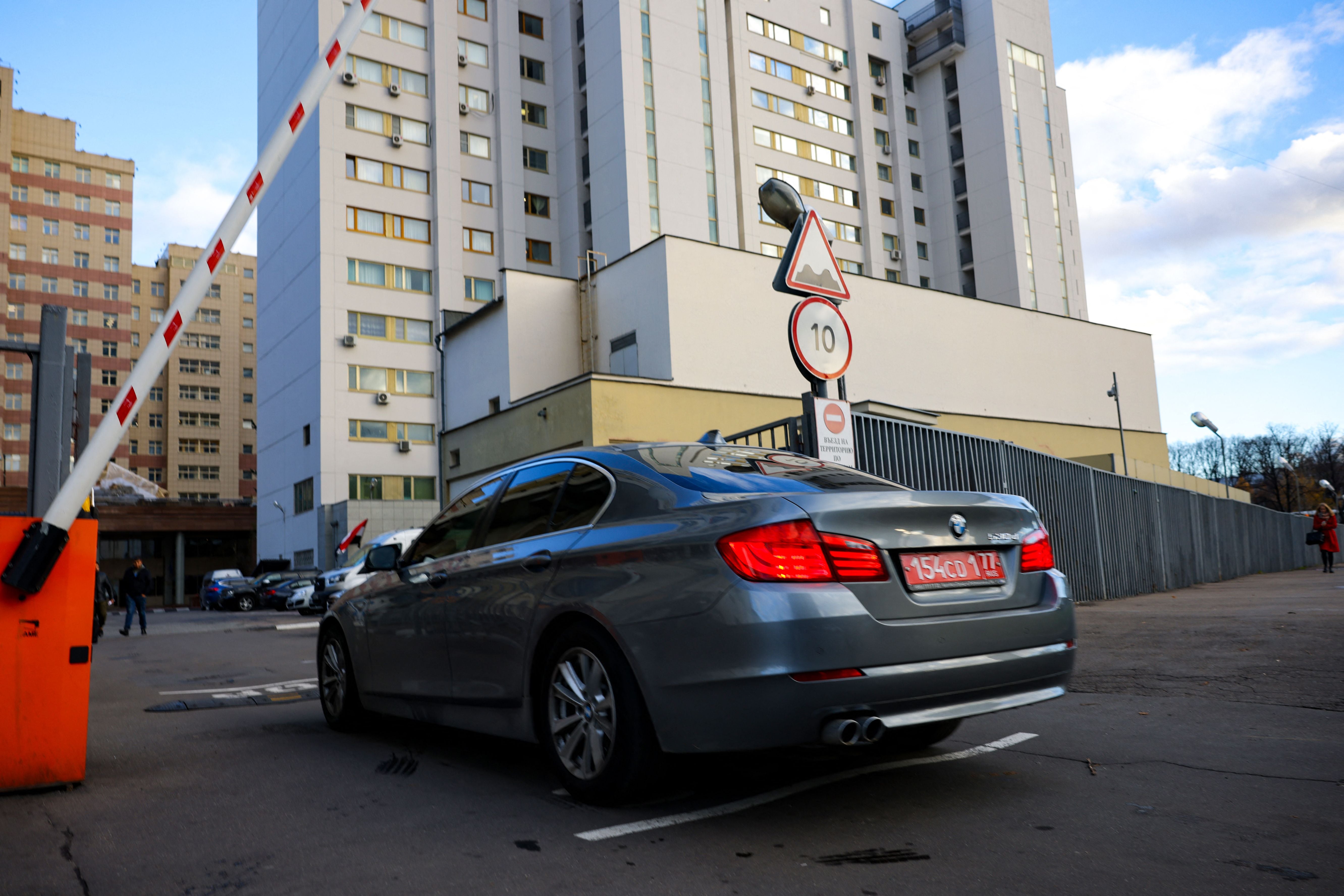 A car with diplomatic license plates enters the grounds of a building that houses the NATO information office in Moscow. Russia said it was suspending its mission to NATO and closing the alliance's offices