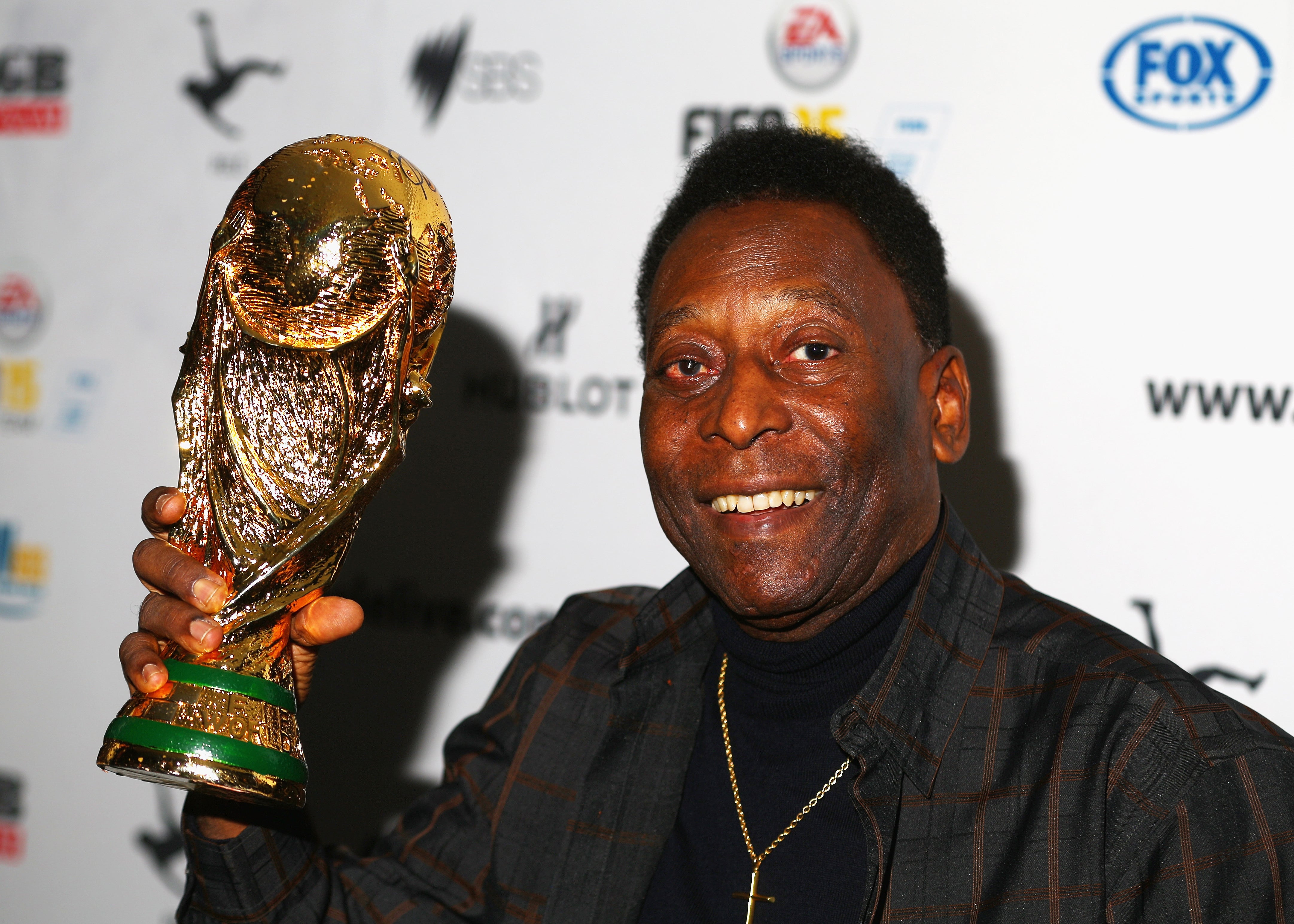 Pele holds a replica World Cup trophy during a press conference in Melbourne in 2015