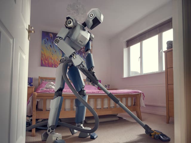 <p>A conceptual image of a generic, blue and white robot holding a vacuum cleaner doing household cleaning chores in bedroom, viewed from a low angle through an open doorway</p>