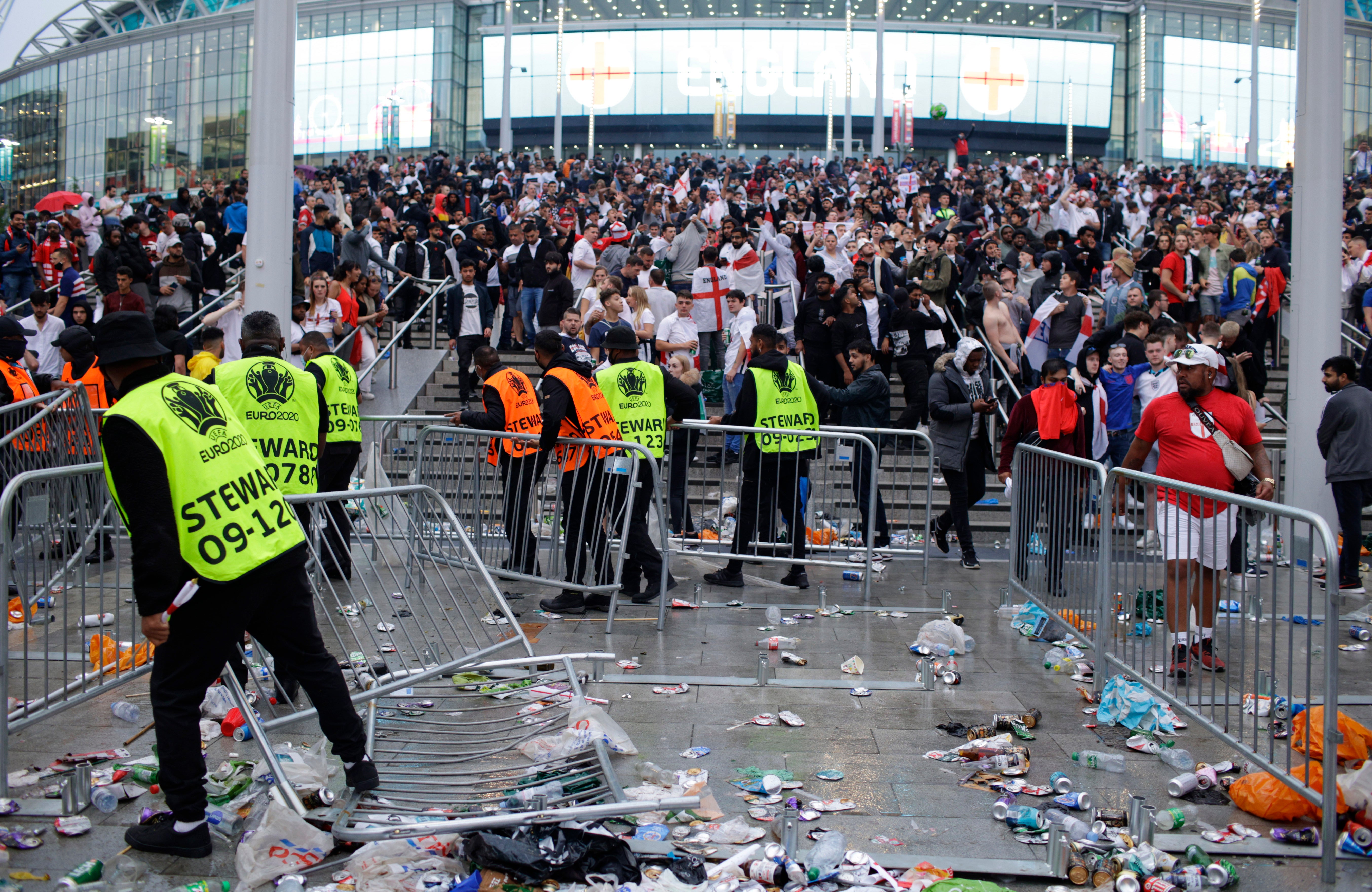 Stewards replace barricades after they were knocked over by supporters outside Wembley during the Euro 2020 final (David Cliff/AP)