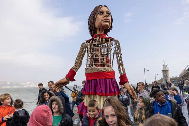 <p>Little Amal was greeted by Jude Law and a group of schoolchildren in Folkestone </p>