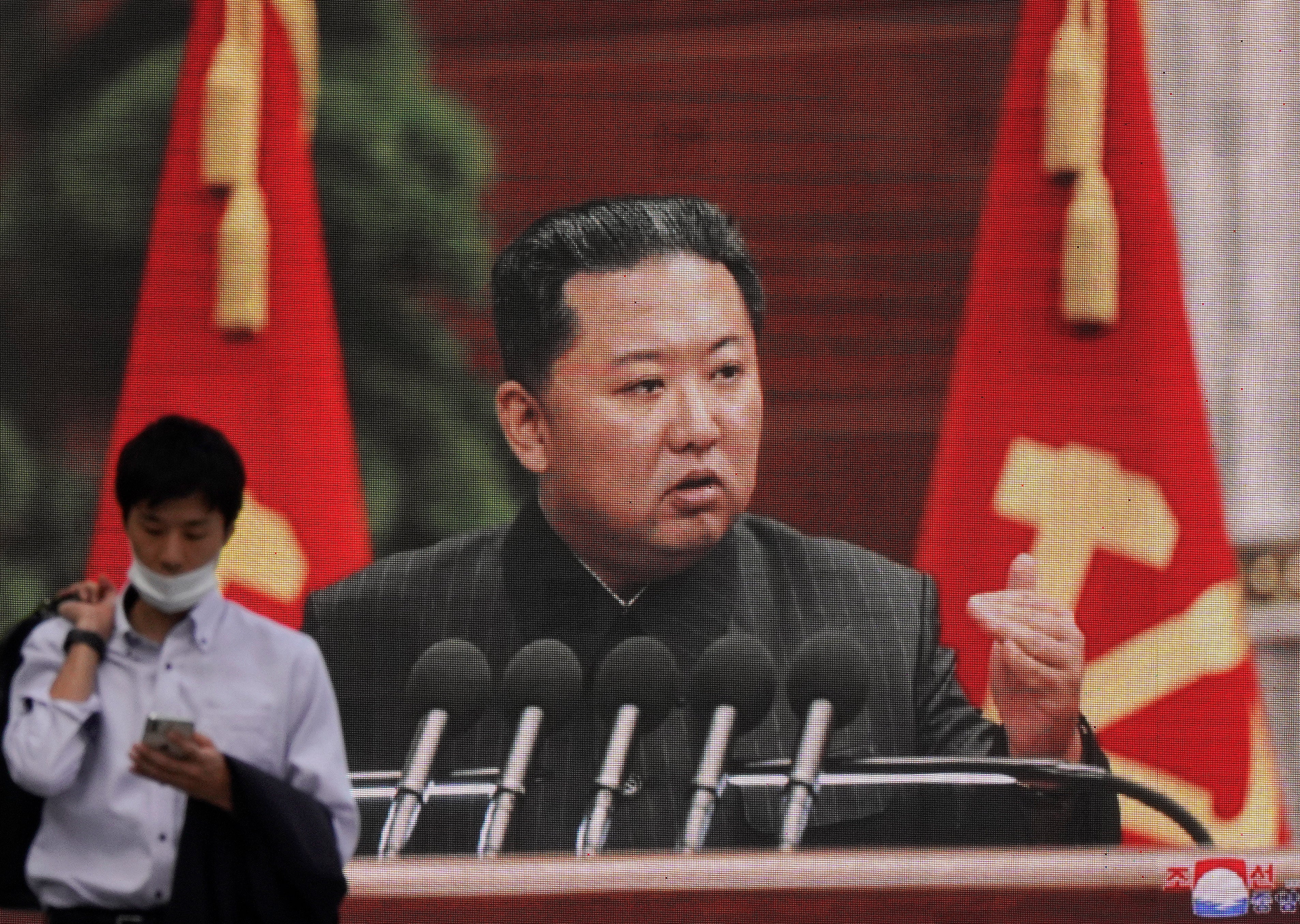 File: A pedestrian walks past a huge screen displaying North Korean leader Kim Jong-un