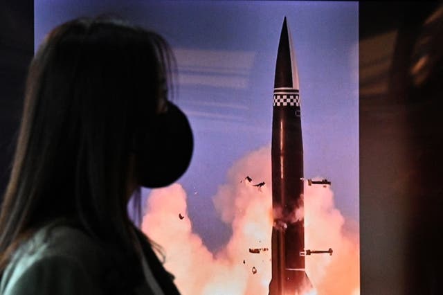 <p>A woman in South Korea walks past a news broadcast of a North Korean missile test on 19 October, 2021. </p>