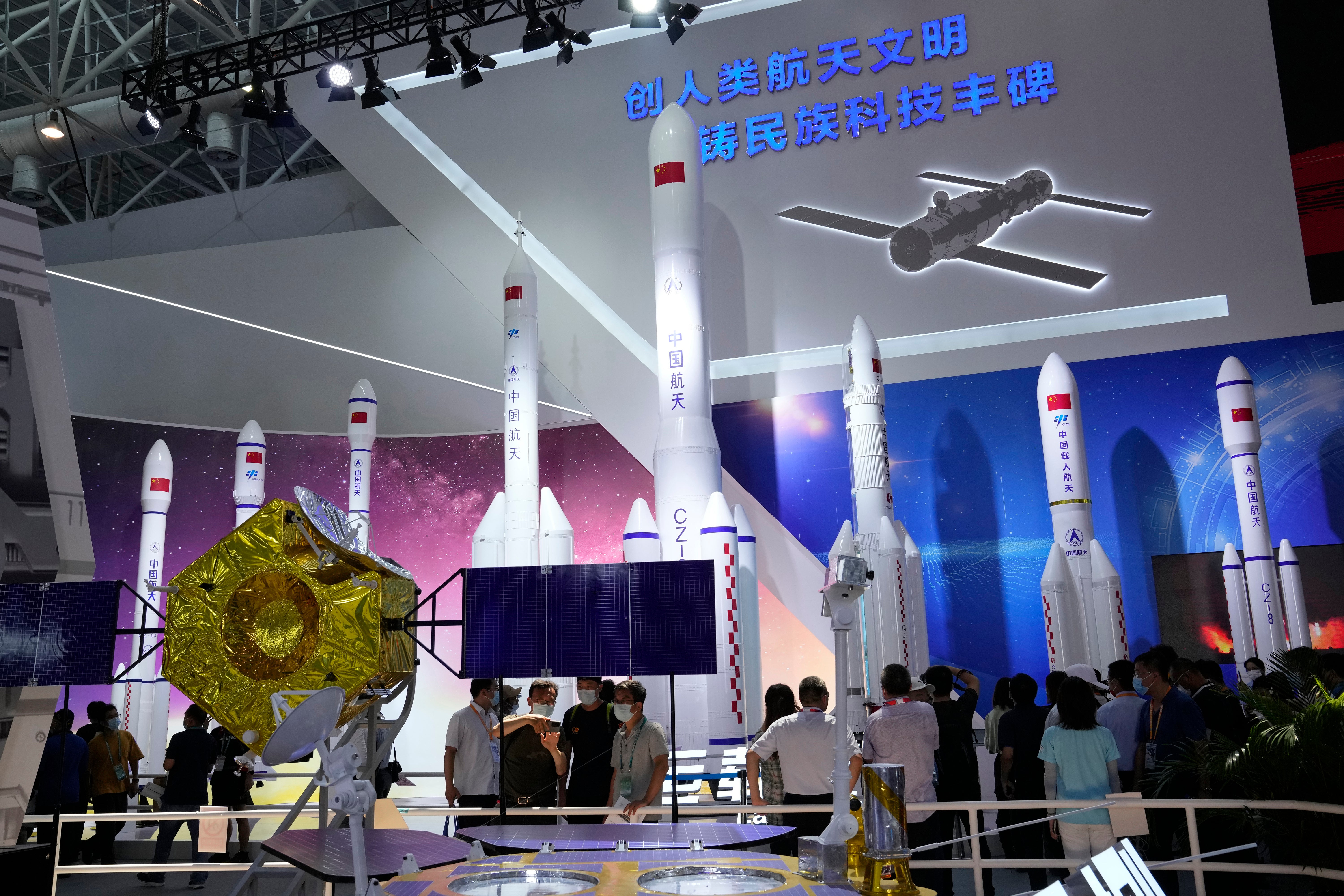 File: Visitors view replica space launch rockets including the first generation rockets for manned launch produced by China Aerospace Science and Technology Corporation at an exhibition on 29 September in Zhuhai