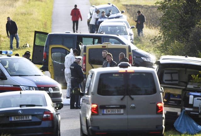 <p>Austrian police are seen near the Austrian-Hungarian border where two refugees were discovered dead inside the yellow van pictured. </p>